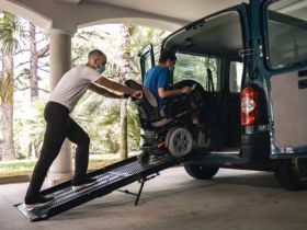 Man in a Wheelchair Being Helped Into a Wheelchair Van in St. Petersburg, FL